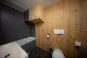 ein Badezimmer mit einem weißen Waschbecken und einer Holzwand in der Unterkunft Le Coucou Hotel Restaurant & Lounge-Bar in Montreux