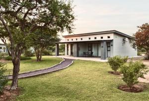 a small white house with a walkway at Symponia Guesthouse in Khanzi