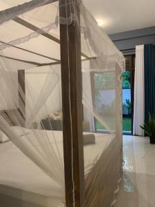 a bed with a net in a room at Menuks villa in Habaraduwa Central