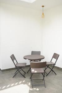 a table and four chairs in a room at Meadow Breeze in Kandy
