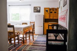 a kitchen with a table and a white refrigerator at Onodilak Guesthouse - Vendégház in Bîrzava +15 photos