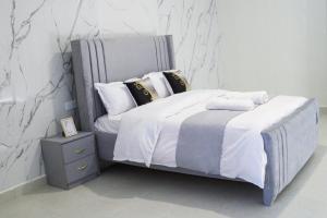 a bedroom with a bed with white sheets and pillows at The Premier Comfort in Nairobi