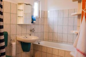 a bathroom with a sink and a bath tub at Onodilak Guesthouse - Vendégház in Bîrzava