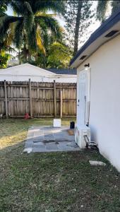 a white house with a door and a fence at Lisboa Shores in Miami