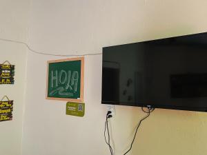 a flat screen tv hanging on a wall at Colombia Hostel in Porto Seguro