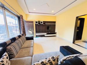 a living room with a couch and a television at Aroma Residency 2bhk villa & delux rooms in Mahabaleshwar