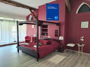 a bedroom with a canopy bed with red walls at Les chambres d'hôtes du Moulin in Arles-sur-Tech