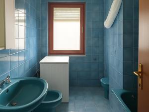 a blue bathroom with a sink and a tub at Dimora del Golfo in Soverato Marina