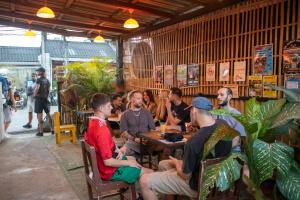 a group of people sitting at a table in a restaurant at Revolution Pai In Town in Pai