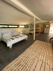a bedroom with a large bed and a large rug at Kalao beach in Cap Skirring