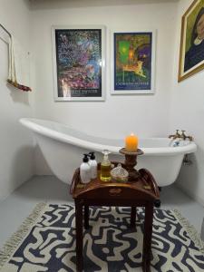 a bathroom with a bath tub and a table with candles at Daniel's Kraal Guest Farm in Calitzdorp