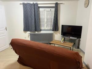 a living room with a couch and a television at Appartement asskaf spacieux T2 in Cambrai