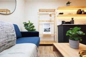 a living room with a blue couch and a table at The Central Swansea Hall 1BR Apartment in Swansea +20 photos