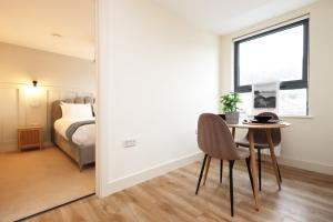 a room with a table and a bed and a window at The Central Swansea Hall 1BR Apartment in Swansea
