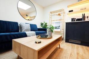 a living room with a blue couch and a table at The Central Swansea Hall 1BR Apartment in Swansea