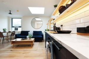 a kitchen with a table and a living room at The Central Swansea Hall 1BR Apartment in Swansea