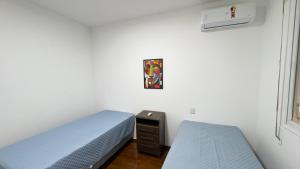 a bedroom with two beds and a window at Edifício Aquarius in Ribeirão Preto