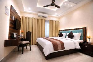 a hotel room with a bed and a desk and a bed sidx sidx sidx sidx at Hotel Crown Patliputra in Patna