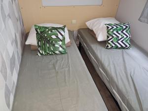 two beds sitting next to each other in a room at Mobil home paisible in Saint-Chéron
