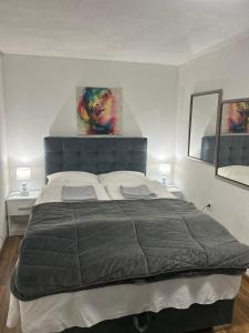 a large bed in a bedroom with two lamps at Apartman MIA in Travnik