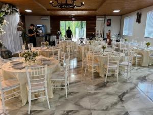 a room full of tables and chairs with people in the background at Sítio novo pousada in Piratuba