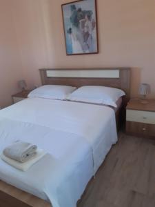 a bedroom with two beds and a picture on the wall at Apartman Barbir in Sukošan