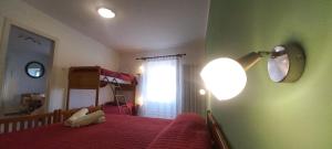 a bedroom with a red bed and a lamp at Casa Floriani Fiavè-Comano Terme green in Fiavè