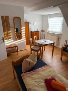 a living room with a bed and a table at Pension Hoffmann Remscheid in Remscheid