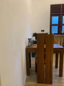 a wooden table and chair in a room with a desk at Menuks villa in Habaraduwa Central +34 photos