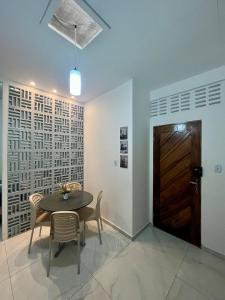 a dining room with a table and chairs and a door at Studio - Serraruna in Araruna