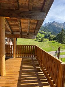 a wooden deck with a view of the mountains at Chalet Gadmer Herz in Gadmen