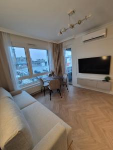 a living room with a couch and a tv and a table at STARCO Apartamenty obok dworca in Stargard