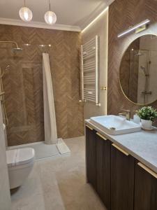 a bathroom with a sink and a toilet and a mirror at STARCO Apartamenty obok dworca in Stargard
