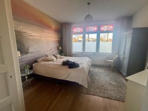 a bedroom with a large bed with a rainbow on the wall at Next To Sea in Vlissingen