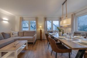 a living room with a couch and a table with chairs at Ankerplatz Sylt in Sylt