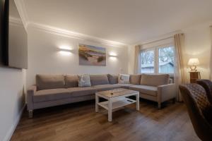 a living room with a couch and a table at Ankerplatz Sylt in Sylt
