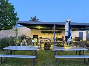 two picnic tables and an umbrella on a patio at Lakeside Motel Waterfront in Lakes Entrance
