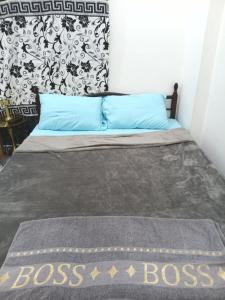 a bedroom with a bed with a boss sign on it at Everest Stay in Abu Dhabi