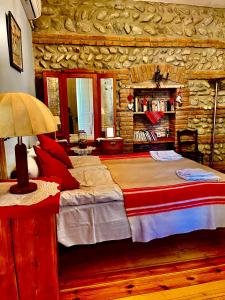 a bedroom with a large bed and a stone wall at Dzveli Galavani -Old Wall in Telavi