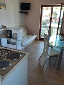 a small room with a table and a bed and a kitchen at Apartman Barbir in Sukošan +19 photos