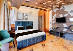 a bedroom with a large bed and a tv at Fun Flock Stay in Mussoorie
