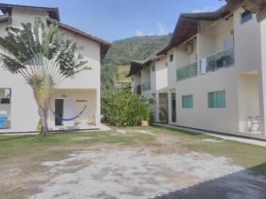 a courtyard with a palm tree and a building at Mares de Camburizinho in Camburi