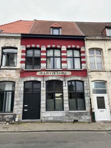 ein rot-weißes Gebäude mit einem Schild darauf in der Unterkunft Cachoire in Tournai