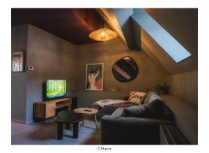 ein Wohnzimmer mit Sofa und Fernseher in der Unterkunft Cachoire in Tournai