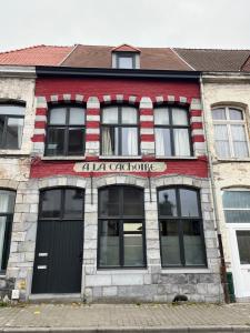 ein rot-weißes Gebäude mit einem Schild darauf in der Unterkunft Cachoire in Tournai + 3 Fotos