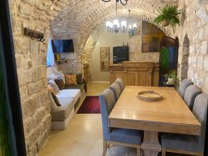 a dining room with a table and chairs and a living room at לאה- וילה בוטנית LEAH- botanical villa in Safed