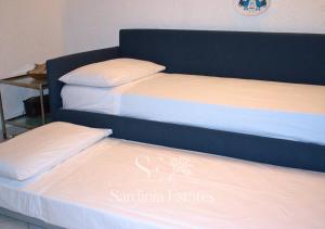 two beds sitting next to each other in a room at Fronte spiaggia con parcheggio - Rainbow House in Porto Rotondo