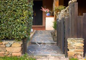 a gate leading to a house with a door at Fronte spiaggia con parcheggio - Rainbow House in Porto Rotondo