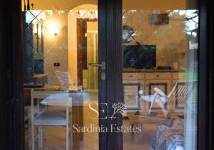 a glass door with a table and chairs in a room at Fronte spiaggia con parcheggio - Rainbow House in Porto Rotondo +42 photos