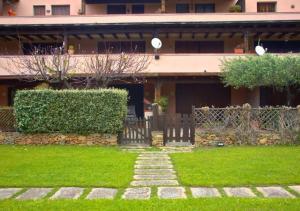 a house with a gate and a grass yard at Fronte spiaggia con parcheggio - Rainbow House in Porto Rotondo